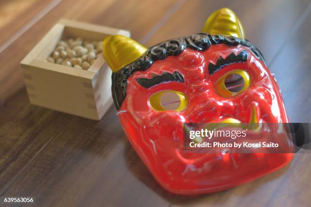 a ogre mask and soybeans for "setsubn" - setsubun stockfoto's en -beelden