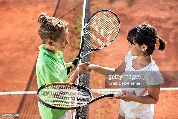 above view of small tennis players shaking hands after match. - tennis boy stock pictures, royalty-free photos & images