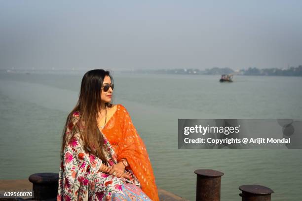 indian woman sitting at harbor in indian ethnic clothing - traditional clothing stock pictures, royalty-free photos & images