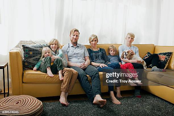 family on sitting on couch - barefoot teen boys stock pictures, royalty-free photos & images