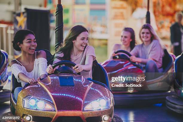 bestfriends driving dodgems - traveling carnival stockfoto's en -beelden