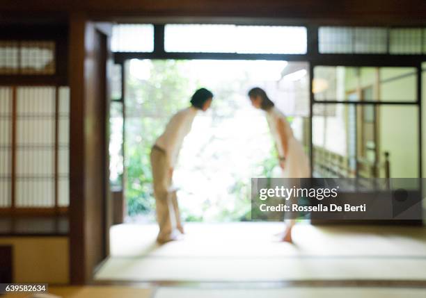 two japanese women bowing with respect in a traditional house - japanese respect stock pictures, royalty-free photos & images