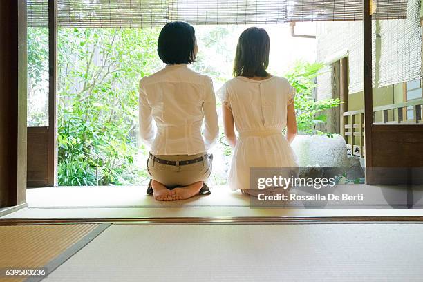 two japanese women contemplating the garden from the veranda - washitsu stock pictures, royalty-free photos & images