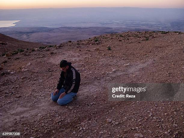 December 27 Mount Nebo, Jordan. Zakariya Ben Badhann, archaeologist and Reza's guide praying on Mount Nebo's ground. For some people, Mount Nebo, 10...