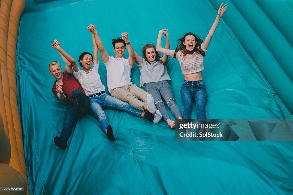 Teens Jumping Down Slide