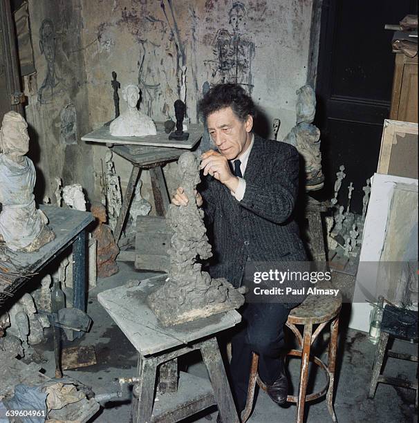 The artist Alberto Giacometti at work on a sculpture in his studio, 1958.