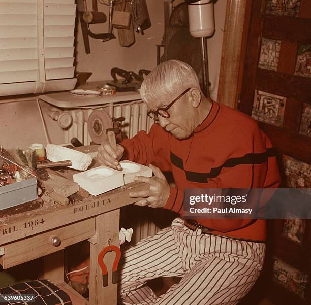 The painter Tsougharu Foujita, also an accomplished carpenter, works in his carpentry shop. France, 1958.