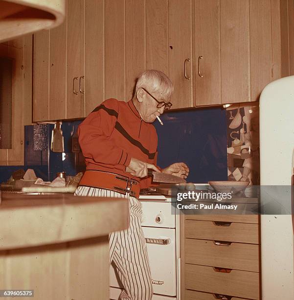 Artist Tsougharu Foujita likes to cook, and is shown here in his kitchen, ca. 1950-1980. | Location: Foujita's house in France.