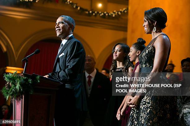 President Barack Obama, first lady Michelle Obama, and daughters Malia and Sasha join the performers on stage during TNT's "Christmas in Washington"...