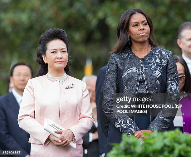 First Lady Michelle Obama and Madame Peng Liyuan of China listen during an official State Visit on the South Lawn of the White House in Washington,...