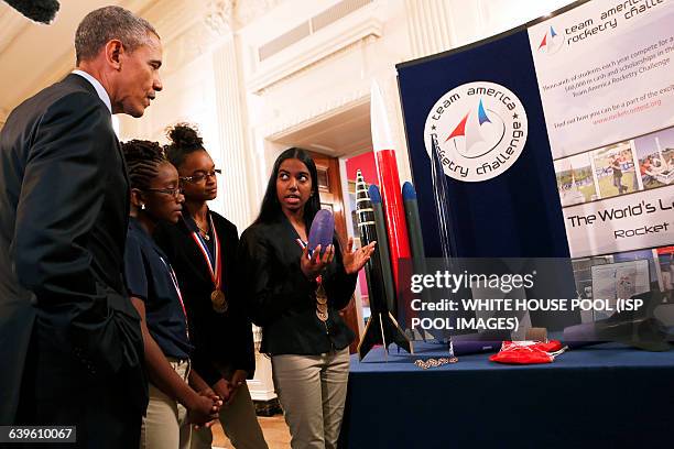 Us President Barack Obama listens to Stephanie Bullock who is part of a team from the US Virgin Islands that design rockets for the Team America...