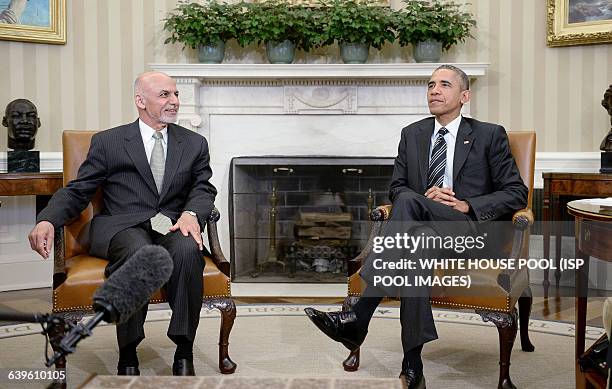 President Barack Obama poses with Afghan President Ghani during a restricted bilateral meeting in the Oval Office of the White House March 24, 2015...