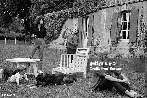 French singer and actress Juliette Greco and her daughter Laurence Lemaire with French novelist Francoise Sagan and a child in a country house.