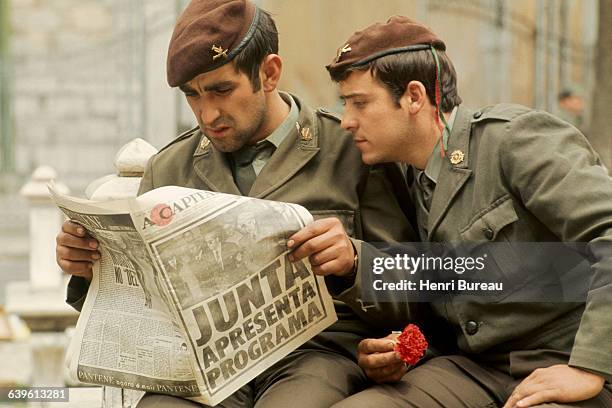 Two Portuguese soldiers reading a newspaper to find out the latest on the Carnation Revolution in Portugal.