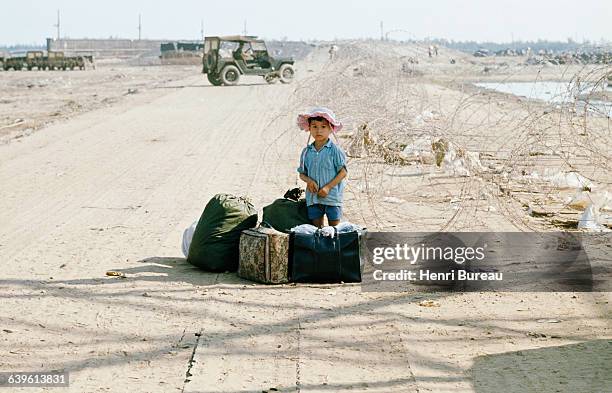 Vietnamese child refugee stands in the road to Hue during the Vietnam War.