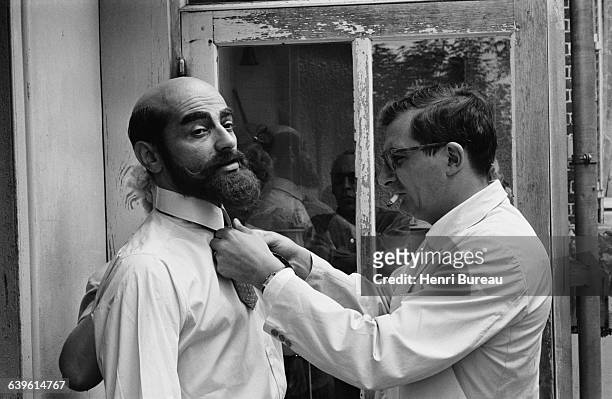 French director Claude Chabrol tidies up actor Charles Denner for a scene of his film Landru.