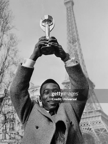 Brazilian soccer legend Pele is in Paris for a friendly match but today he appears in front of the Eiffel Tower, holding the FIFA World Cup trophy....