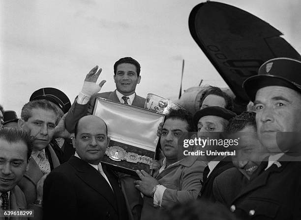 Robert Cohen is carried off with his champion's belt upon arrival at the airport in France after becoming bantamweight World Champion in Bangkok....