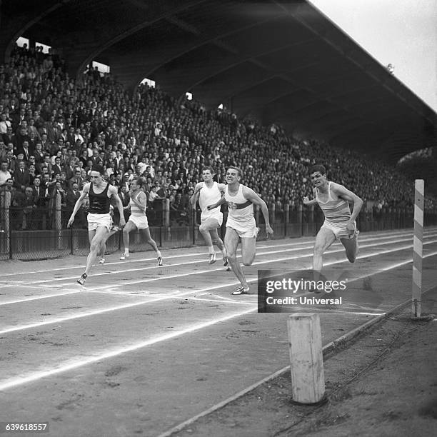 Peter Radford, David, Robbie Brightwell, Armin Hary and Jocelyn Delecour at the finish of a men's 100-meter race at Stade Jean-Bouin.