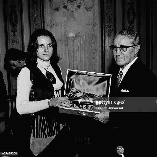 Mrs. Muller receives the Soulier d'Or for her husband Gerd from Adolf Dassler, known as Adi Dassler. Dassler is the founder of the German sportswear...