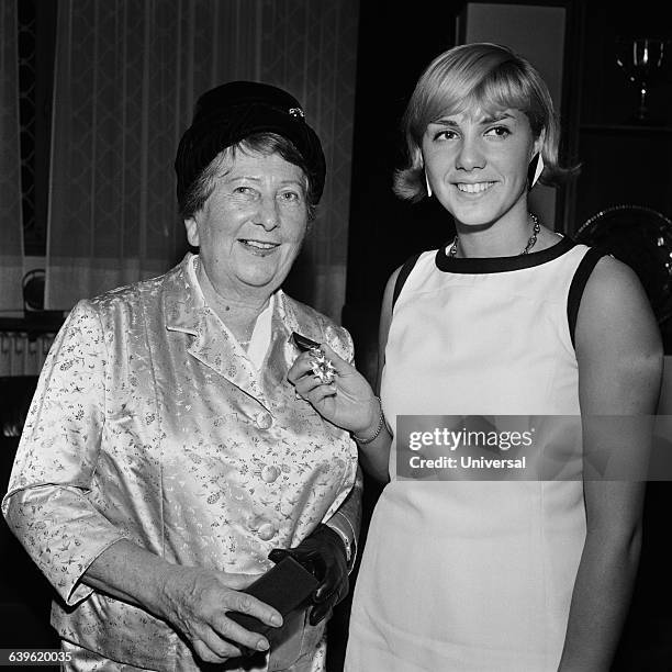 Famous swimming coach Suzanne Berlioux receiving the Legion d'Honneur in the presence of French swimmer Christine "Kiki" Caron .