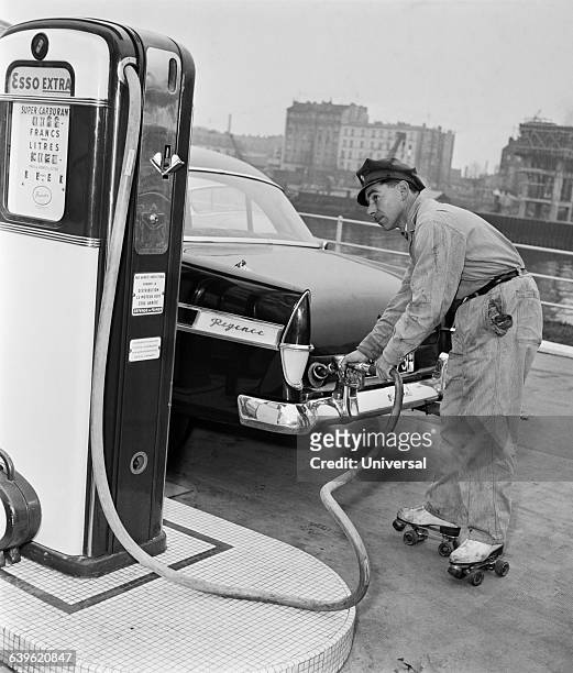 Gas station attendant on roller skates fills the tank of a car.