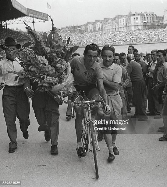 Italian cyclist Fausto Coppi makes a victory lap in the Parc des Princes after winning the 1949 Tour de France. The 21st and final stage was between...