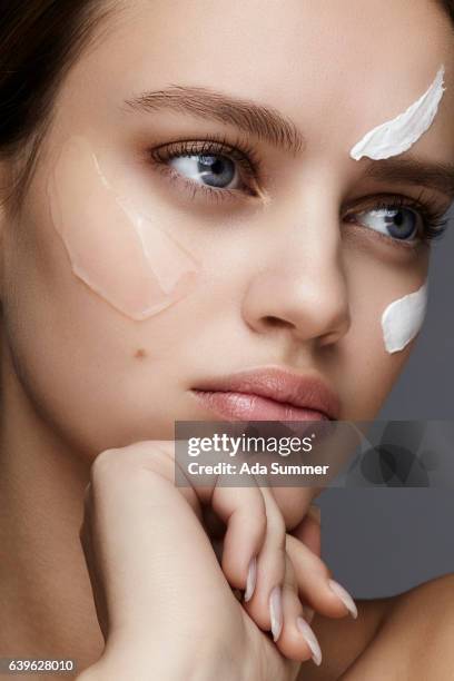 close up of a young woman with cream and gel on her face - blank room stockfoto's en -beelden