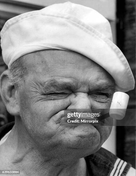 Picture from a series of humurous novelty images taken by Sunday People photographer Dennis Hutchinson. A gurning Popeye look-a-like. Circa: 1980.