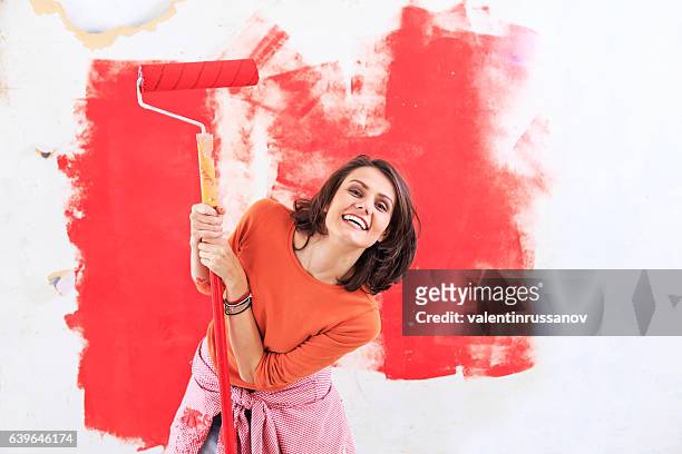 smiling woman having fun and decorating - woman painting stock pictures, royalty-free photos & images