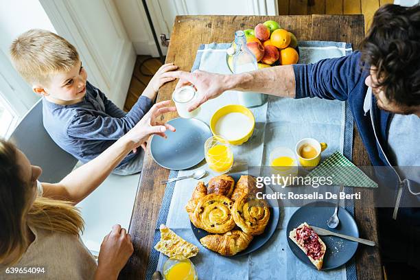 happy family having breakfast together at home - pain au chocolat stock pictures, royalty-free photos & images