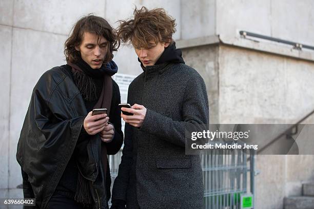 Two models check their phone after the Lanvin show Palais de Tokyo on January 22, 2017 in Paris, France.