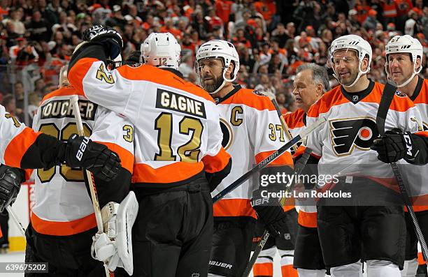 Brian Boucher, Simon Gagne, Eric Desjardins and Mikael Renberg of the Philadelphia Flyers Alumni celebrate with teammates following their game...