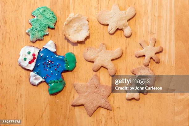 sugar cookies on wooden table, some with decorative icing - sugar cookie stock pictures, royalty-free photos & images