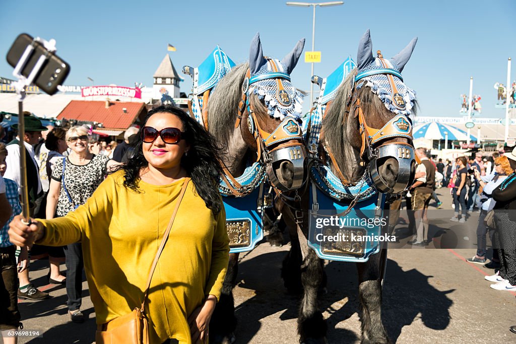 Donna che si fa un selfie con i cavalli all'Oktoberfest