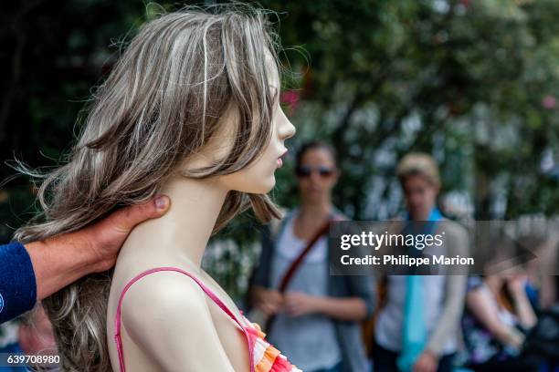 a male hand places a firm grip on the back of the neck of a woman mannequin - domestic violence men stock pictures, royalty-free photos & images