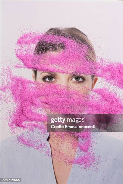 young woman's face looking through pink sand - human face collage stock pictures, royalty-free photos & images