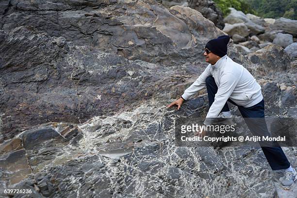 middle aged man climbing rocky hills in himalayan mountain, rishikesh - rishikesh meditation stock pictures, royalty-free photos & images