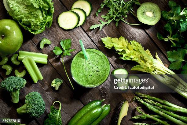 detox diet concept: green vegetables on wooden table - berry smoothie stock pictures, royalty-free photos & images
