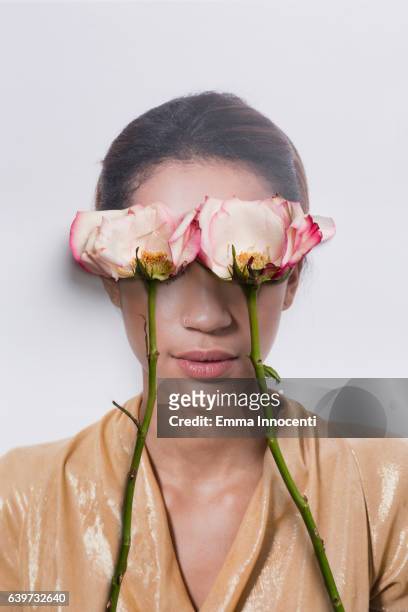 Young woman's eyes covered by roses