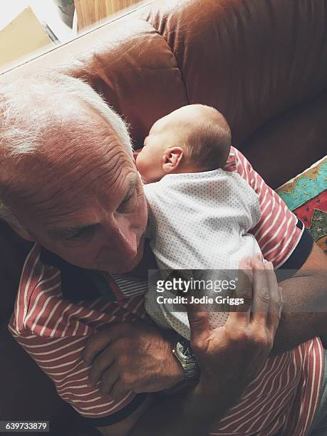 grandfather holding onto newborn baby grandchild - babyhood bildbanksfoton och bilder