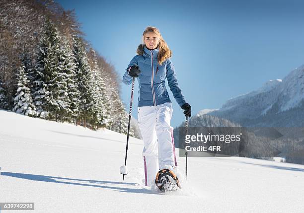 donna ciasciata attraverso un paese delle meraviglie invernale, alpi austriache - racchetta da neve attrezzatura sportiva foto e immagini stock