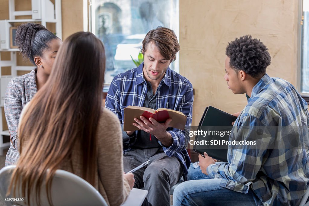 Caucasian man reads Bible with study group