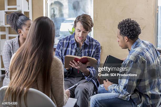 caucasian man reads bible with study group - church group stock pictures, royalty-free photos & images