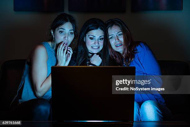 three girlfriends, watchng something scary on laptop - tv program stockfoto's en -beelden