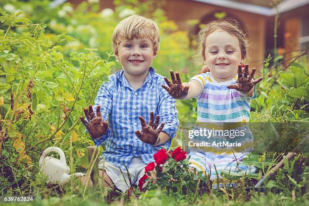 happy little girl and boy in garden - happy dirty child stockfoto's en -beelden