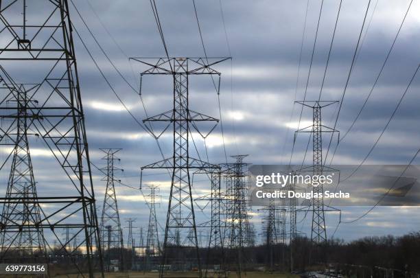multiple power lines on overhead towers - kilowatt stock-fotos und bilder