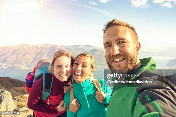 drei junge erwachsene beim wandern machen selfie auf dem berg - bergsteiger gruppe stock-fotos und bilder