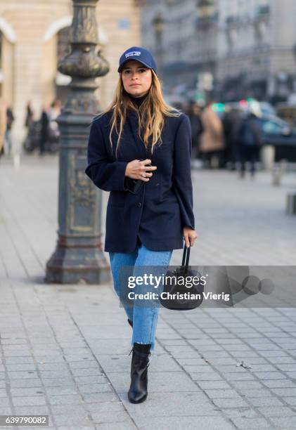 Miroslava Duma wearing a navy jacket a navy Patagonia cap, black bag, cropped denim jeans, ankle boots outside Schiaparelli on January 23, 2017 in...