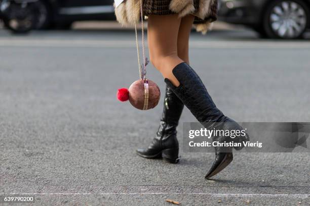 Guest wearing a fur jacket and black boots outside Dior on January 23, 2017 in Paris, Canada.